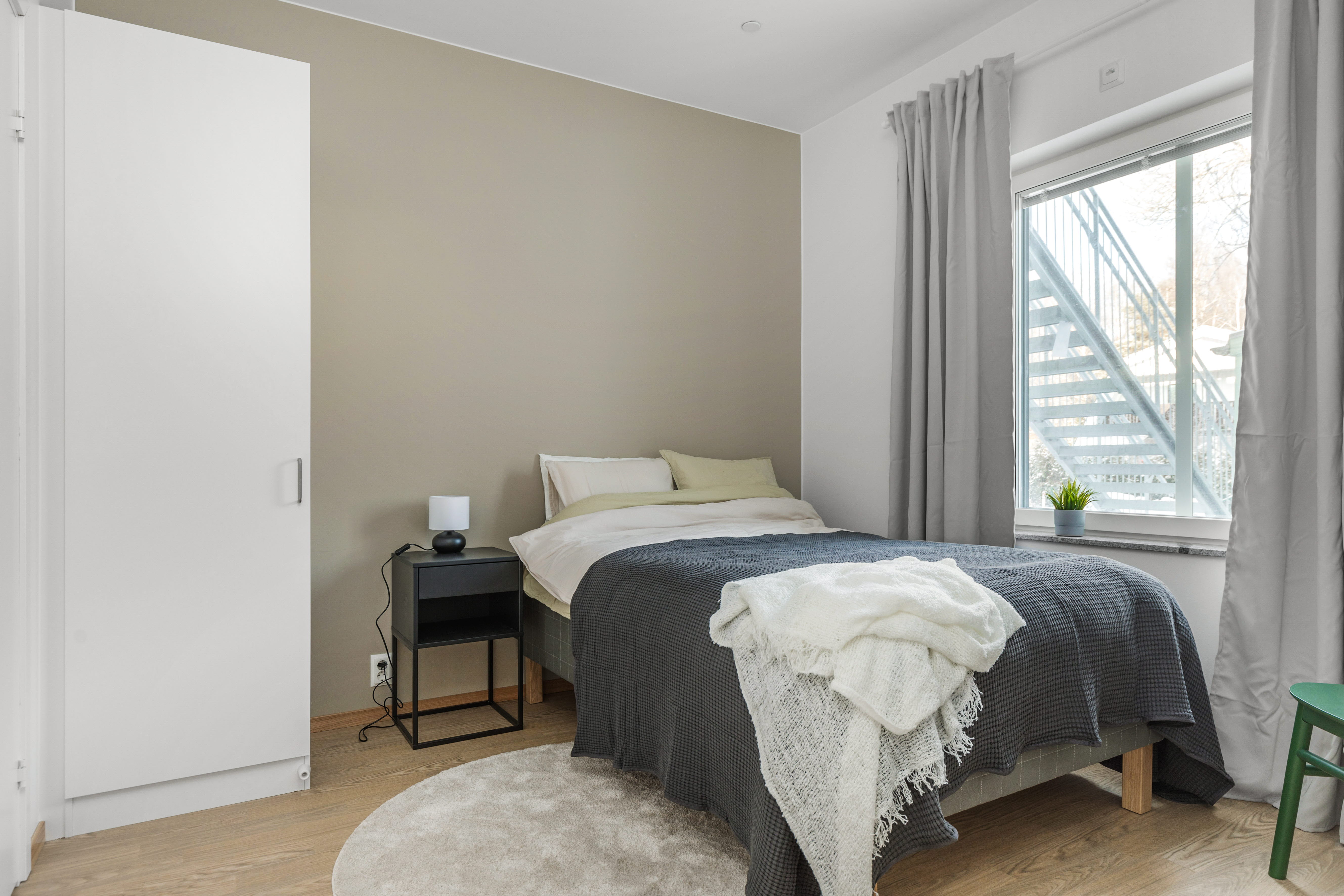 A bedroom with a bed and window in a room