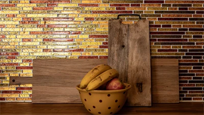 Bild på fruktskål mot mosaikvägg. 