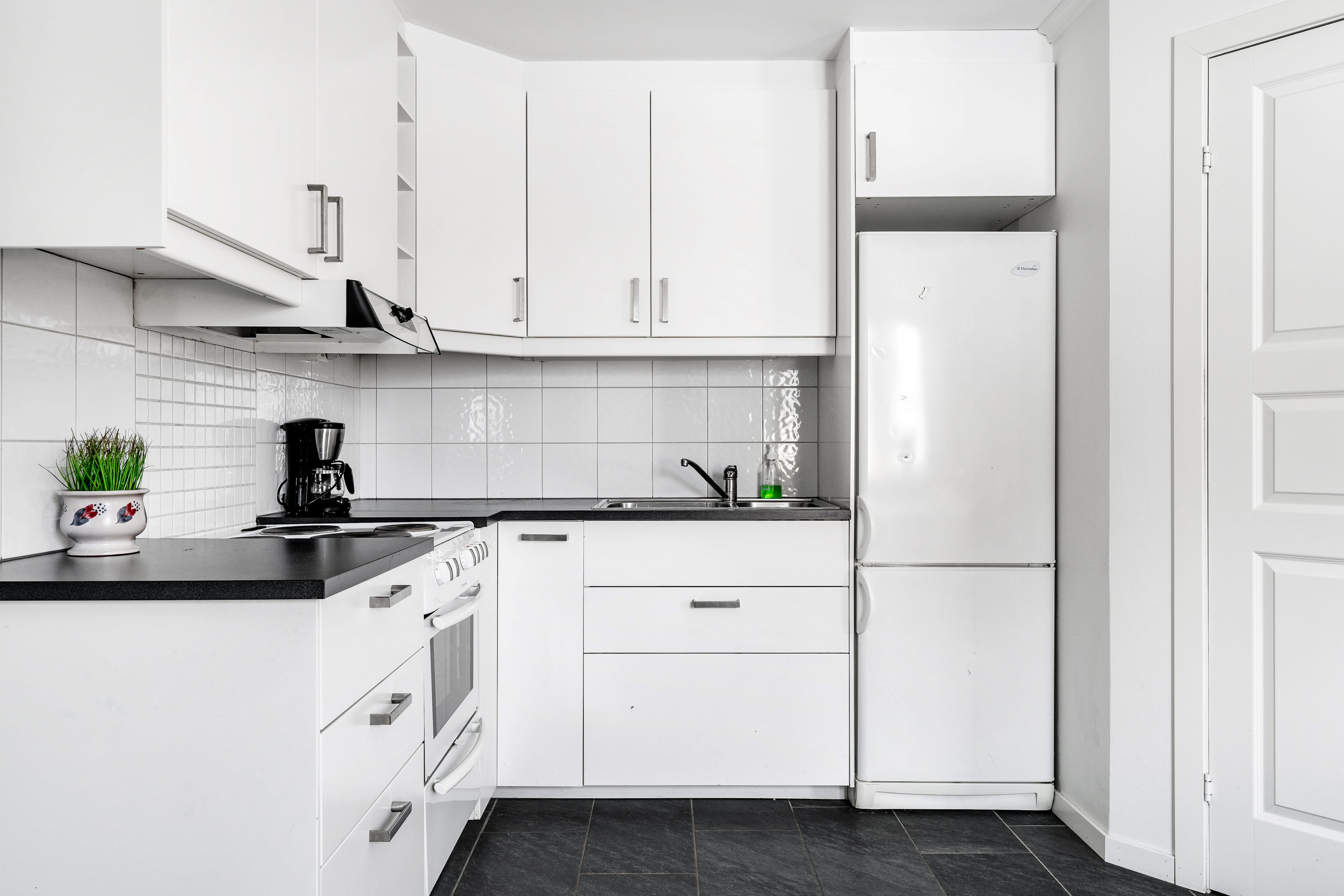 A kitchen with a stove and a refrigerator