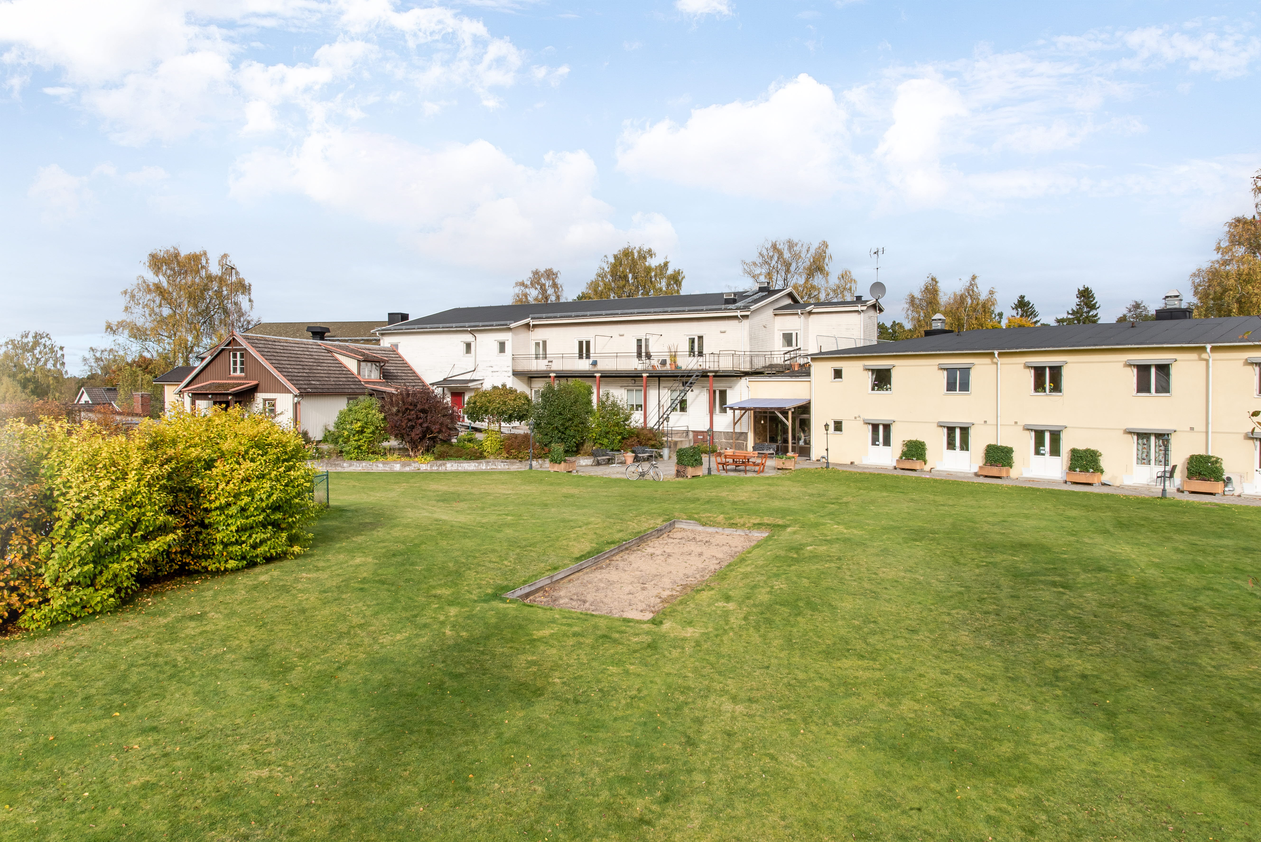 A large green field in front of a house