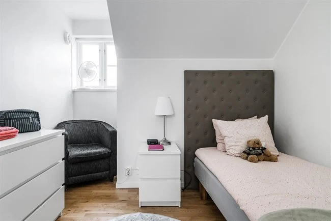 A bedroom with a bed and a couch in a living room