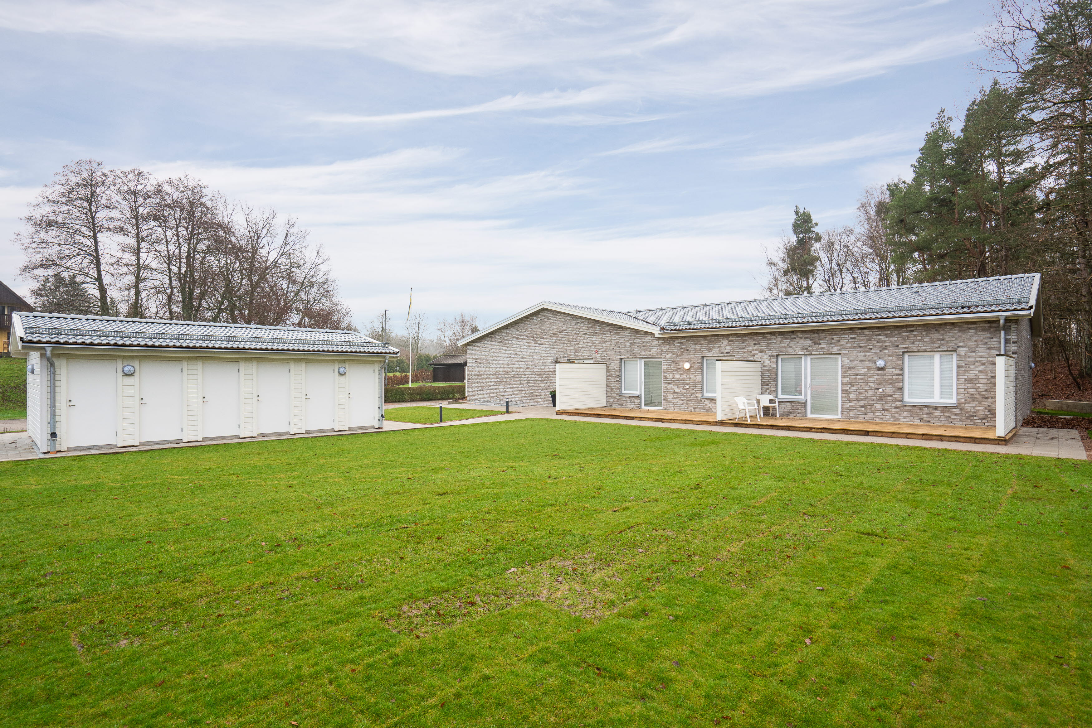 A large green field in front of a house