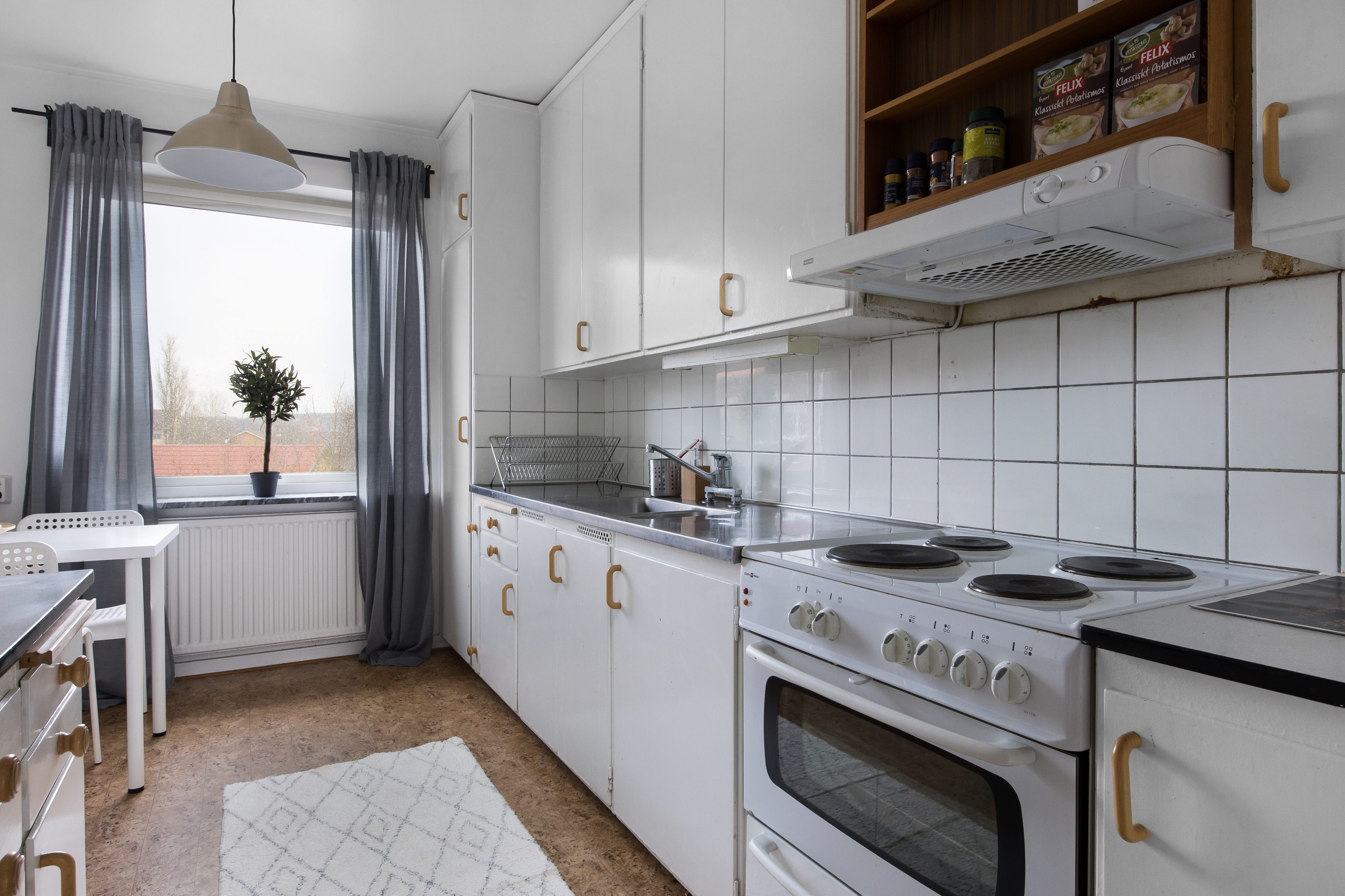 A kitchen with a stove top oven sitting next to a window