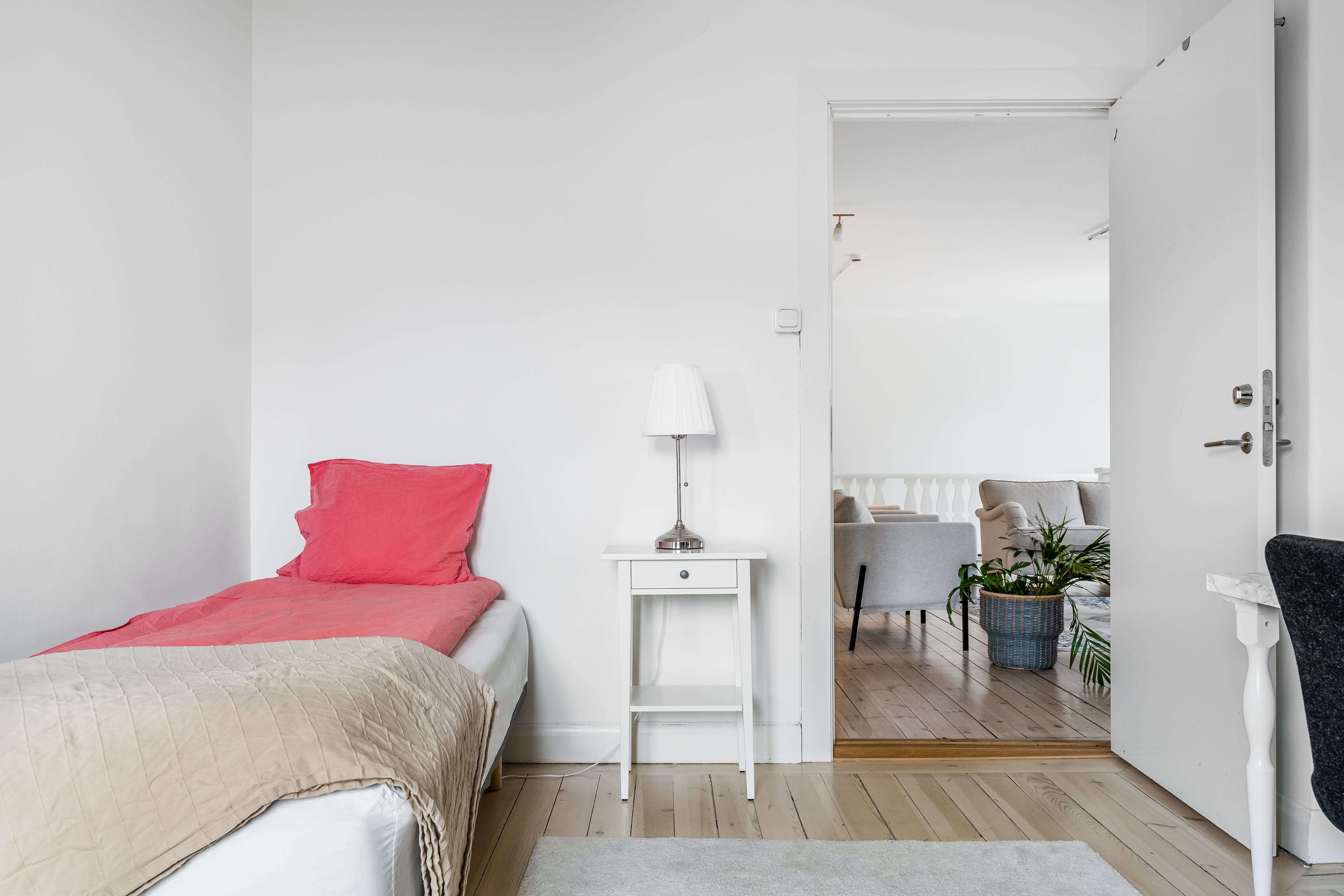 A bedroom with a bed and a chair in a room
