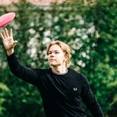 Nuori mies heittää frisbeetä.