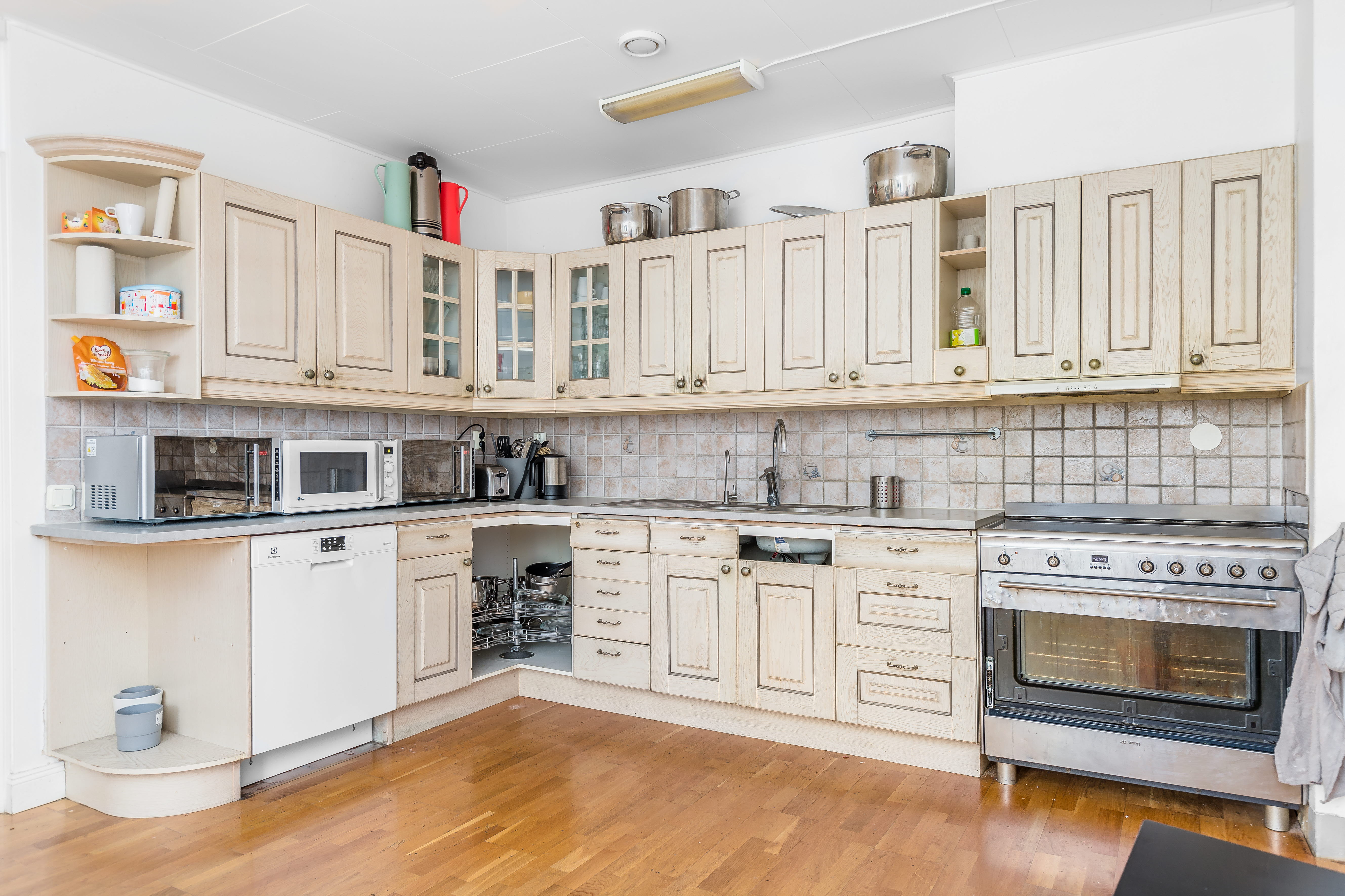 A kitchen with a stove top oven sitting inside of a hard wood floor
