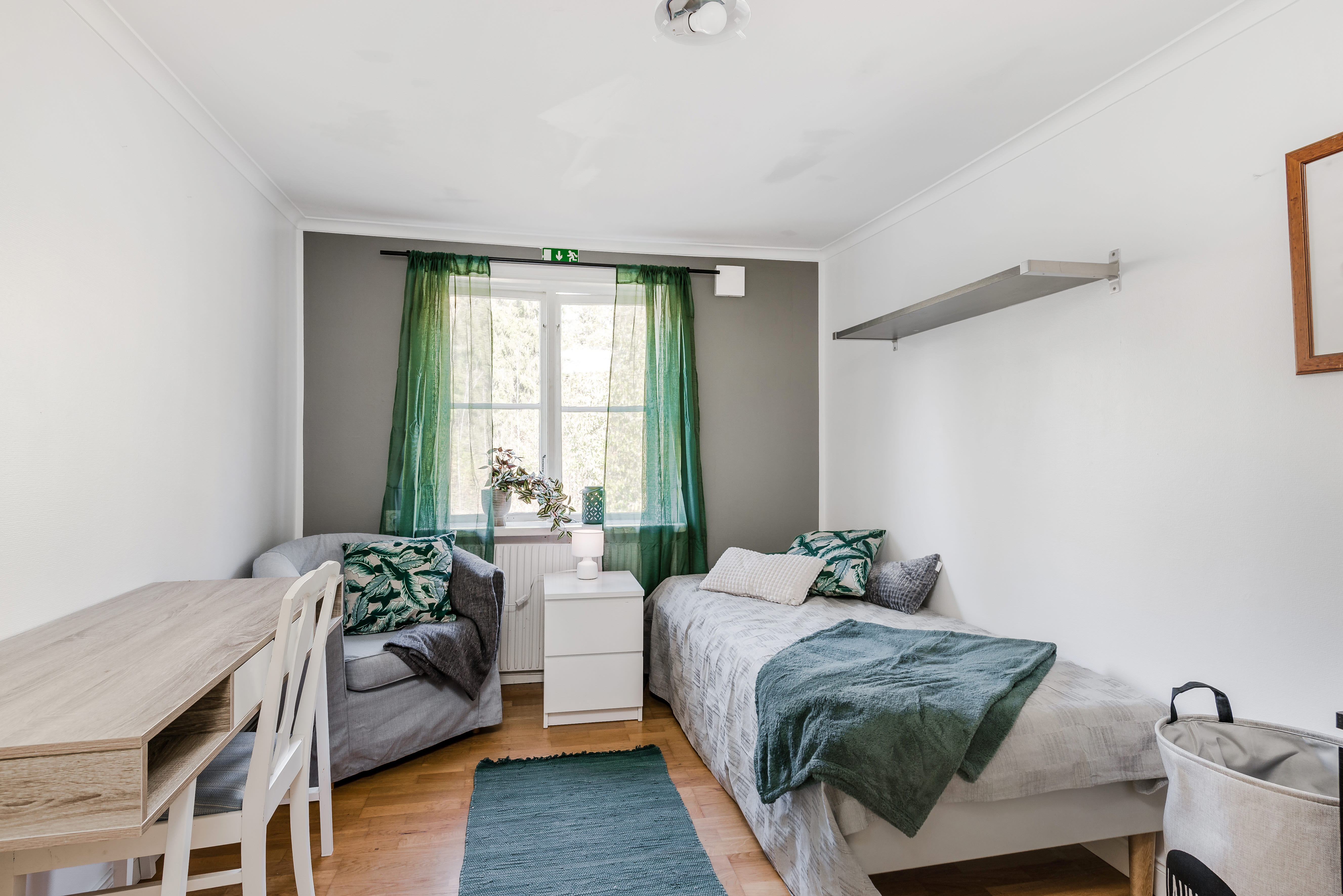 A bedroom with a bed and a chair in a room