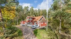 Vy över ett rött hus på Alma Gård