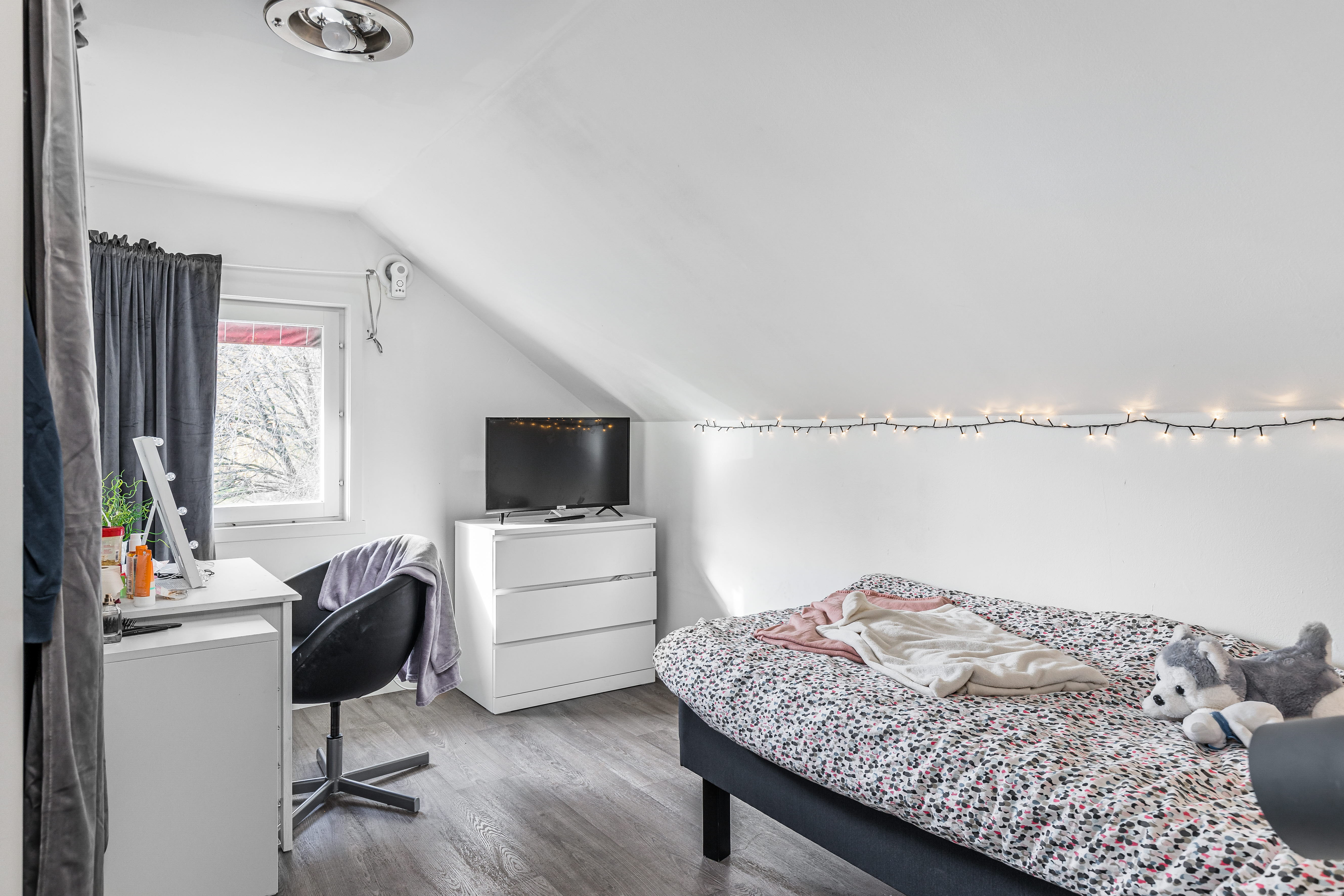 A bedroom with a bed and desk in a room
