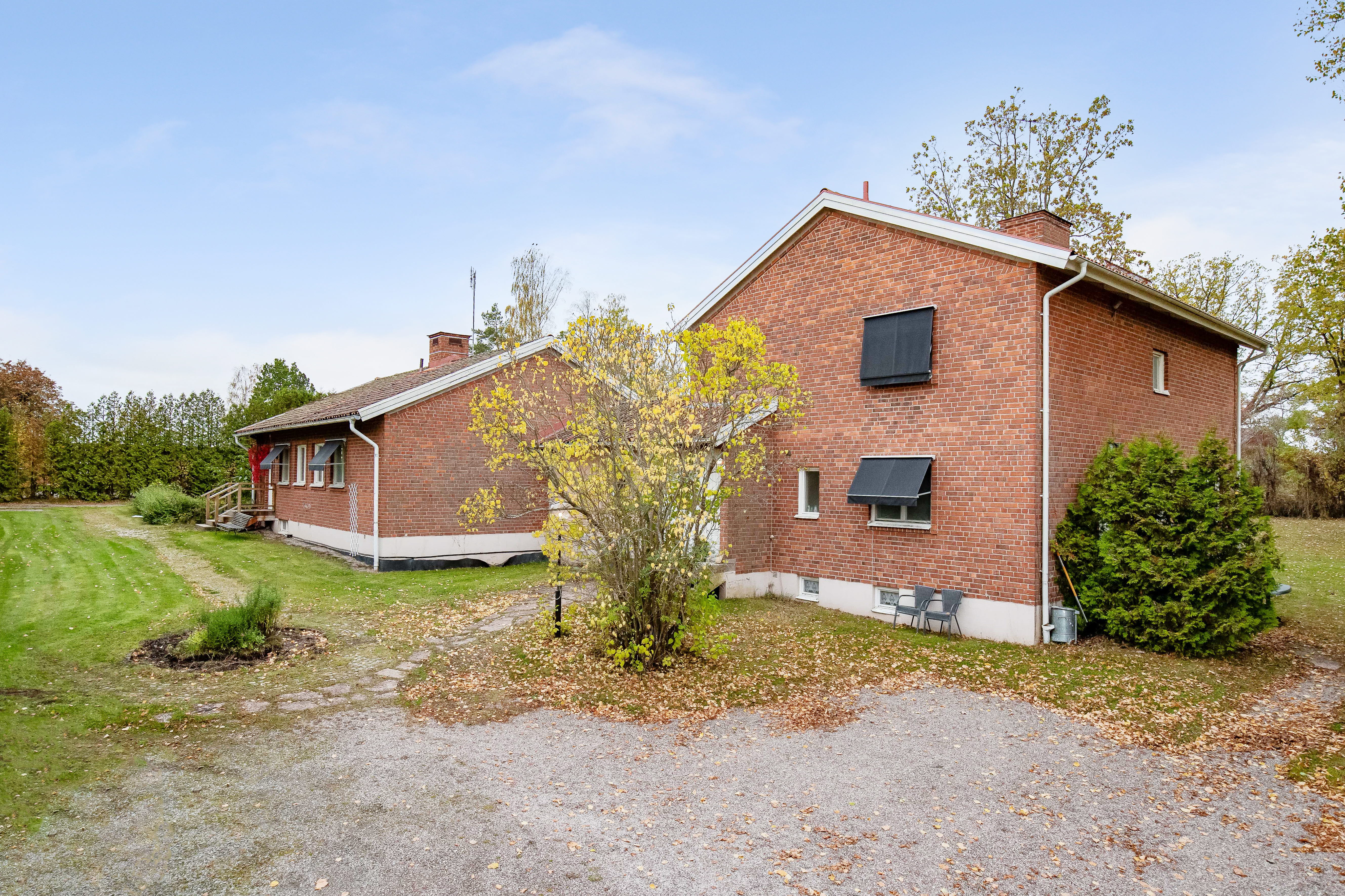 A large brick building with grass in front of a house
