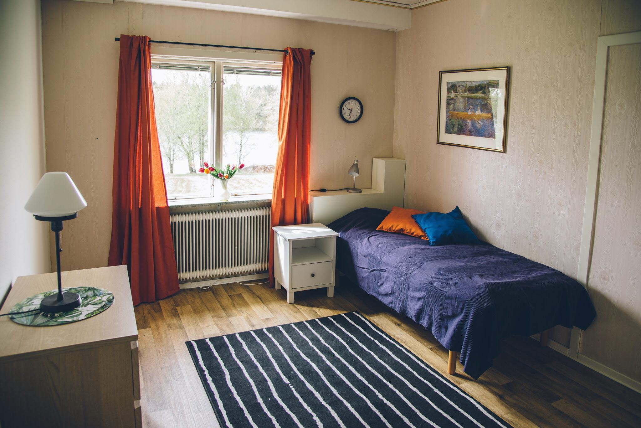 A bedroom with a bed and desk in a small room