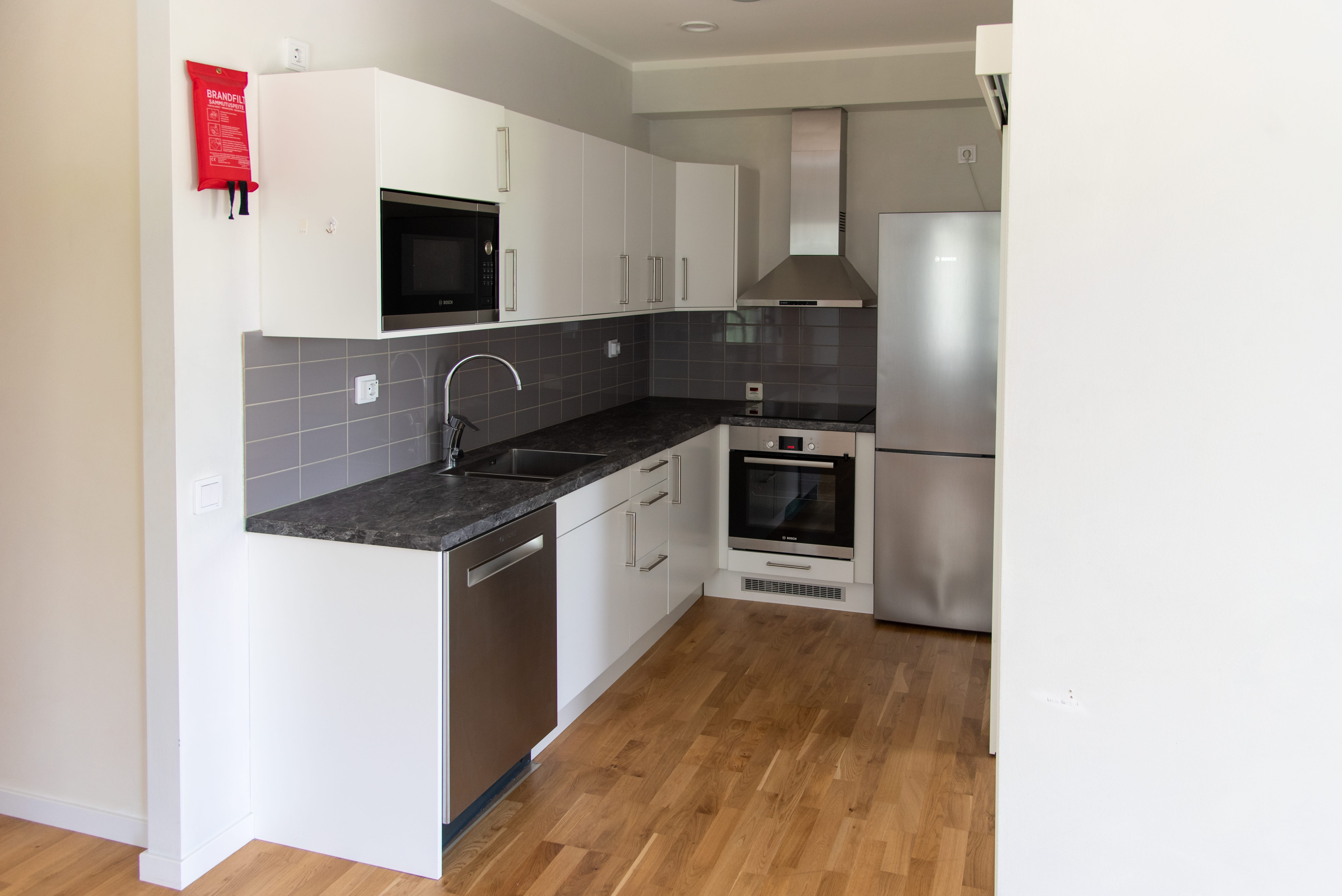 A large kitchen with stainless steel appliances and wooden cabinets