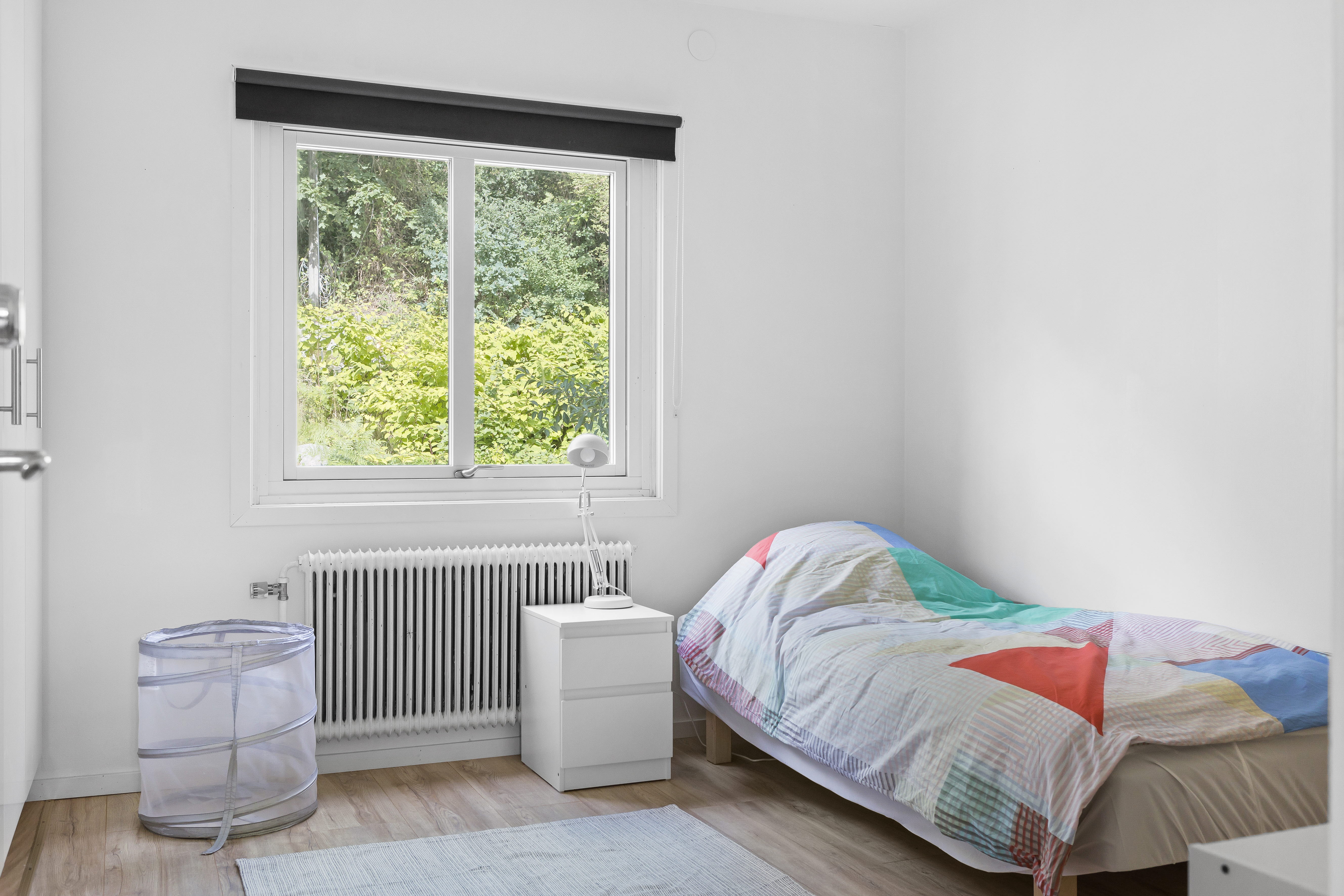 A bedroom with a bed and a window