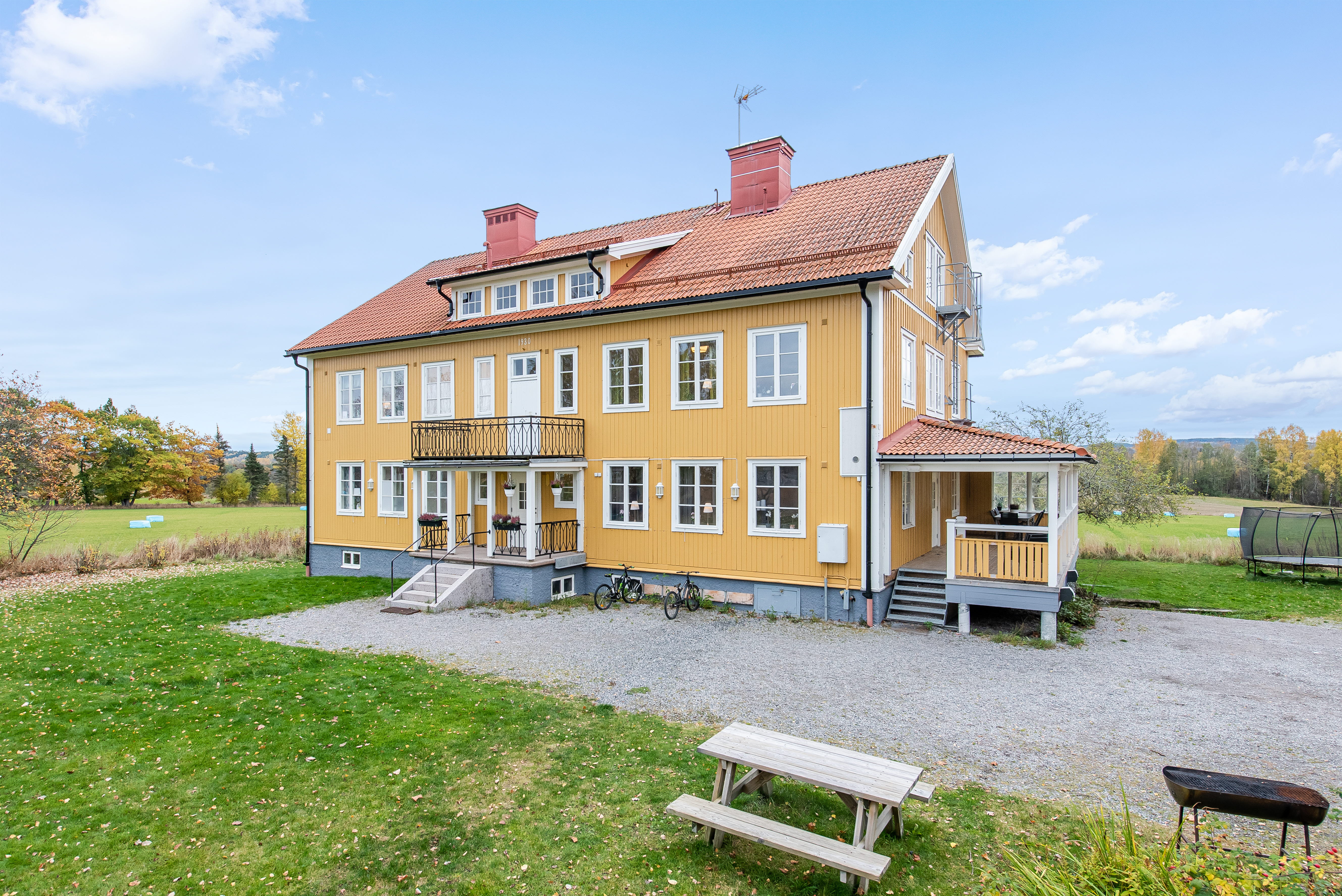 A wooden bench sitting in front of a house with Russian Bishop's House in the background