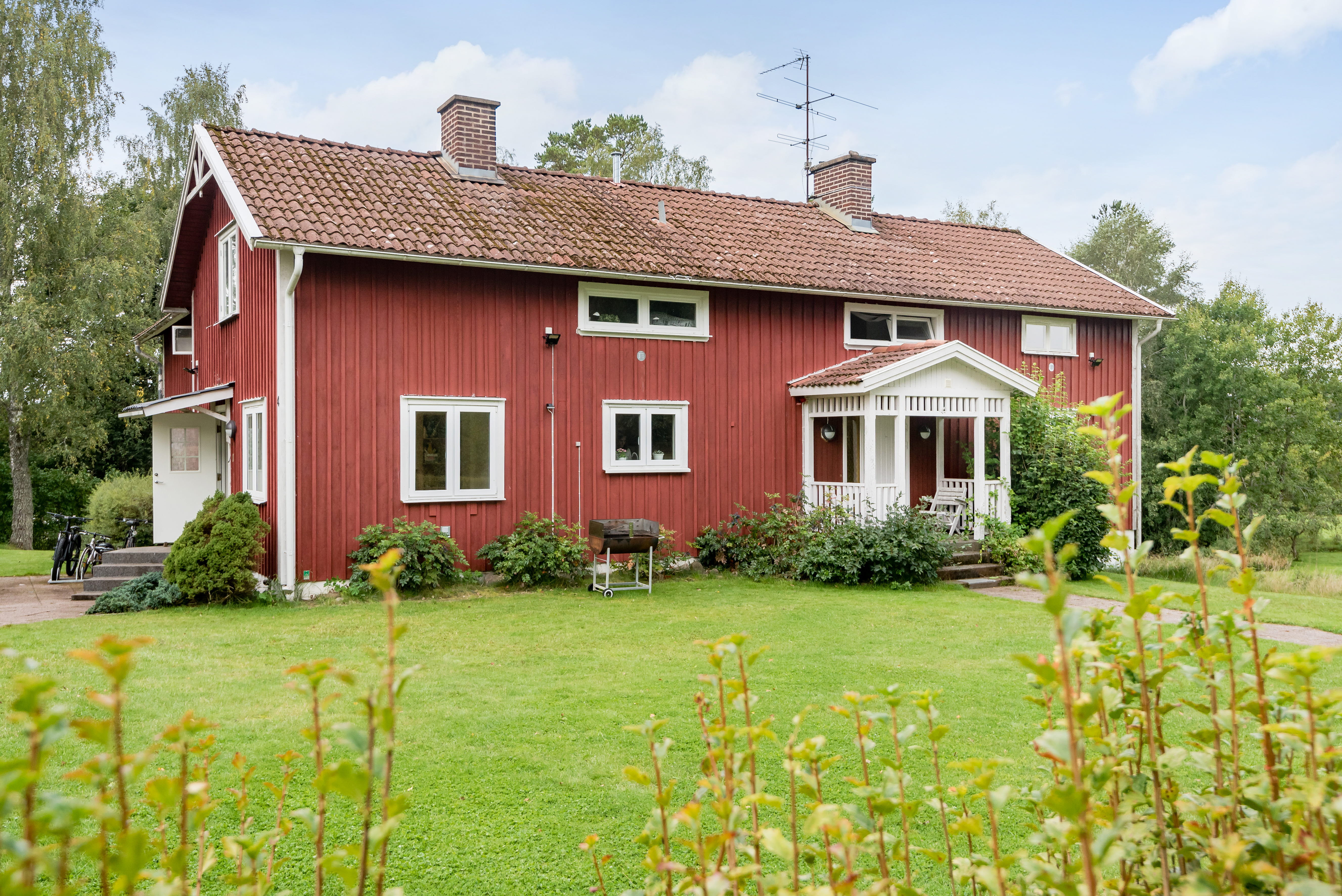 A large green field in front of a house