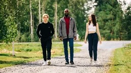A group of people walking down a dirt road