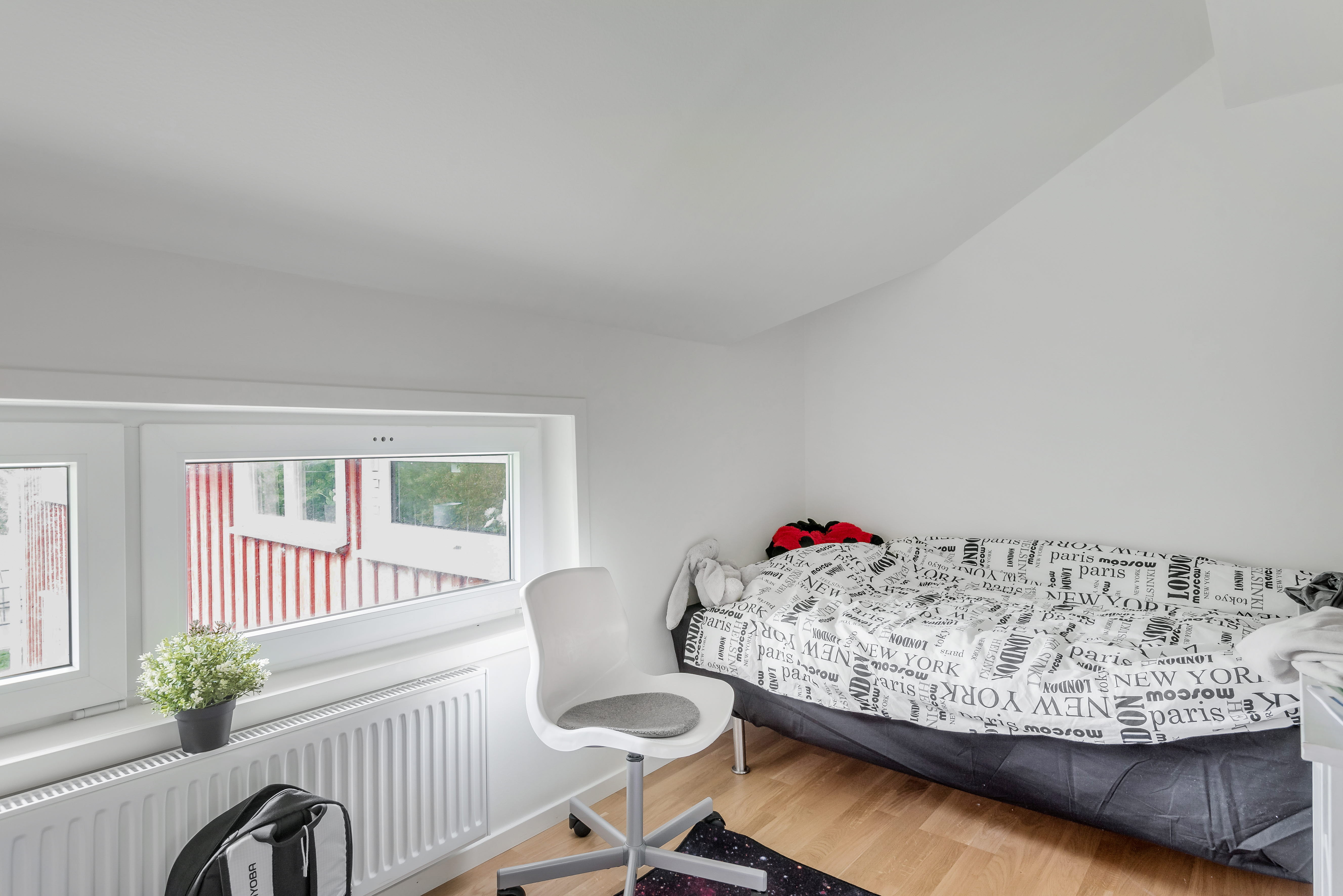 A bedroom with a bed and desk in a room