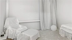 Helvitt rum med möbler täckta i vitt tyg.