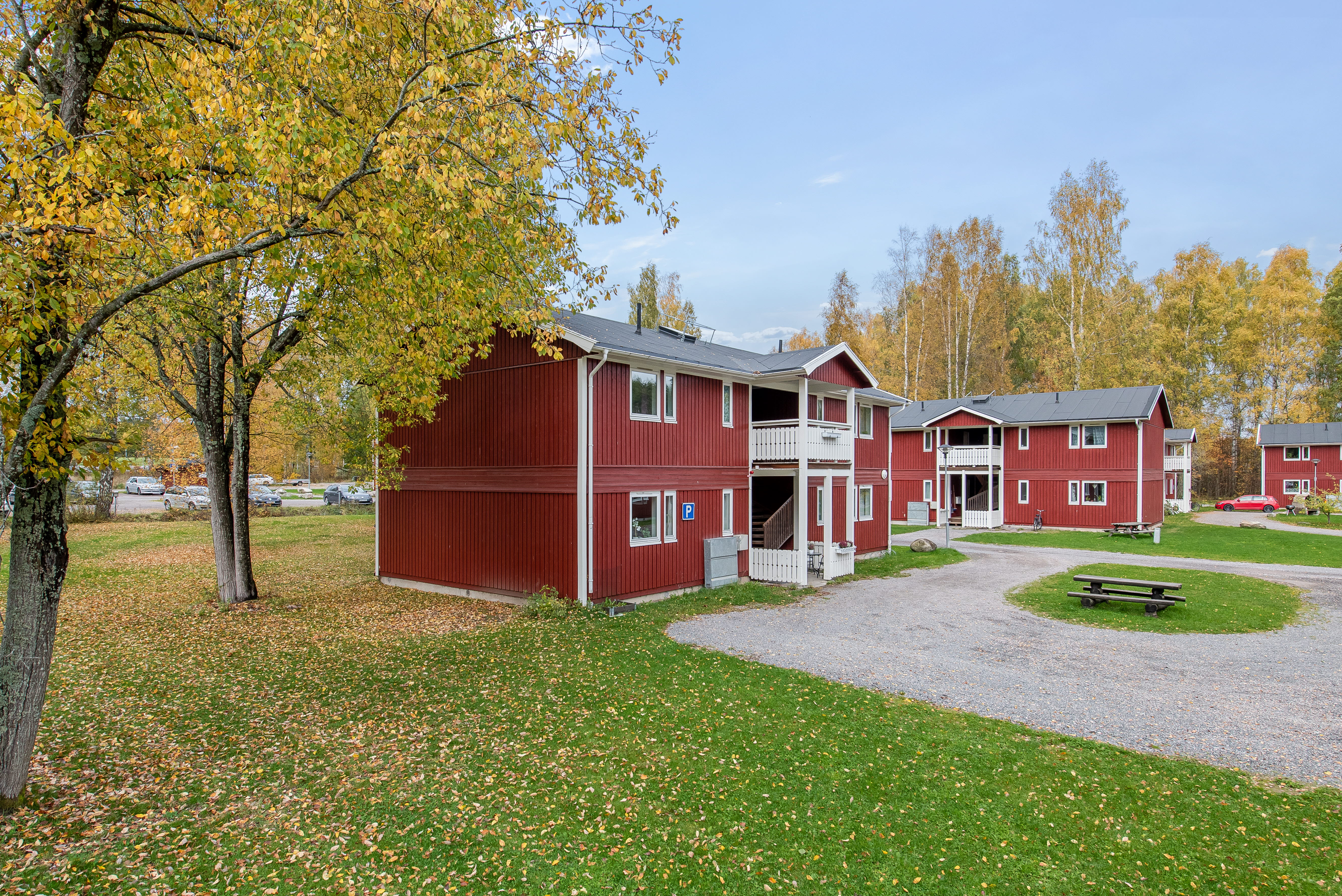 A small house in a grassy area with trees in the background