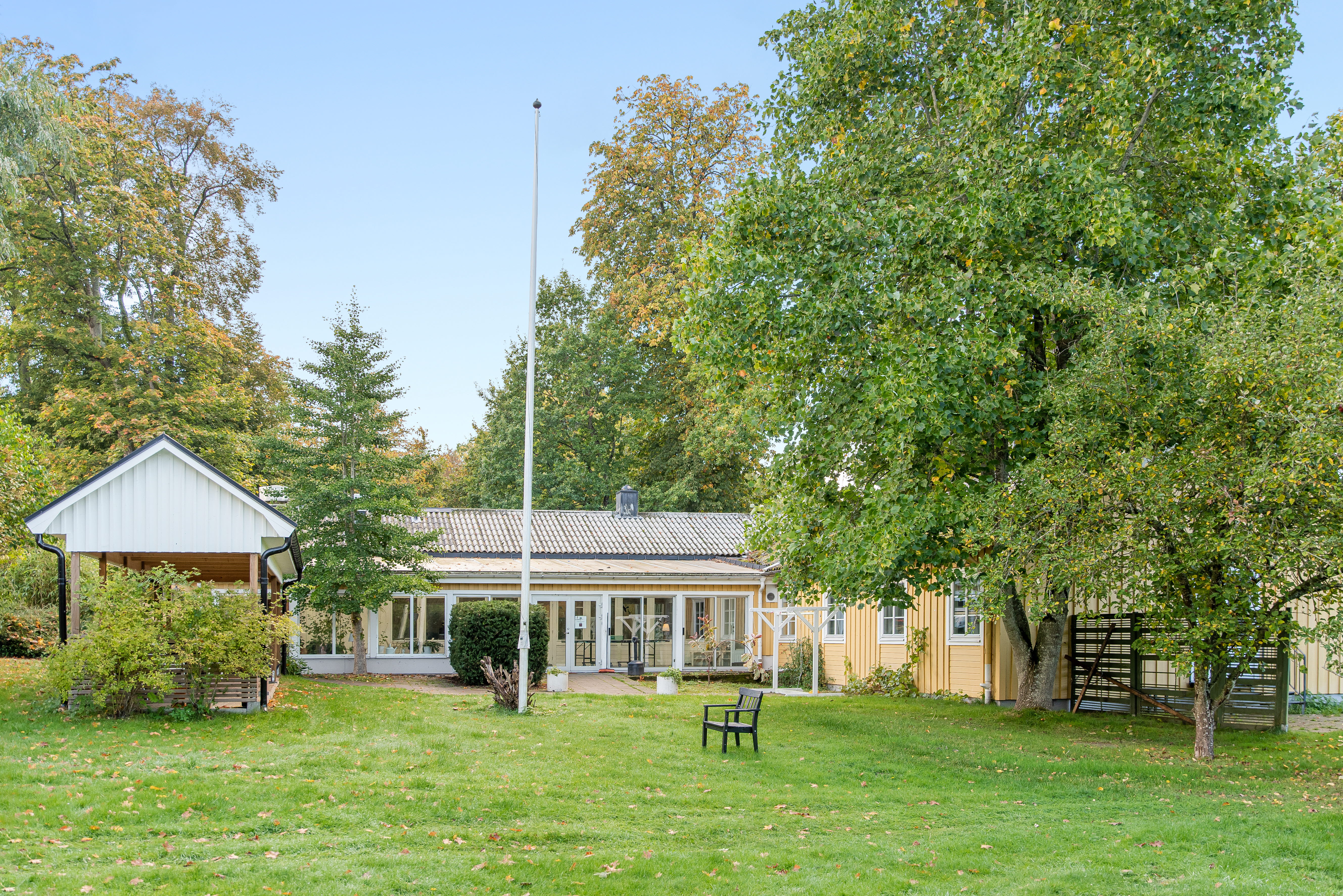 A large green field in front of a house