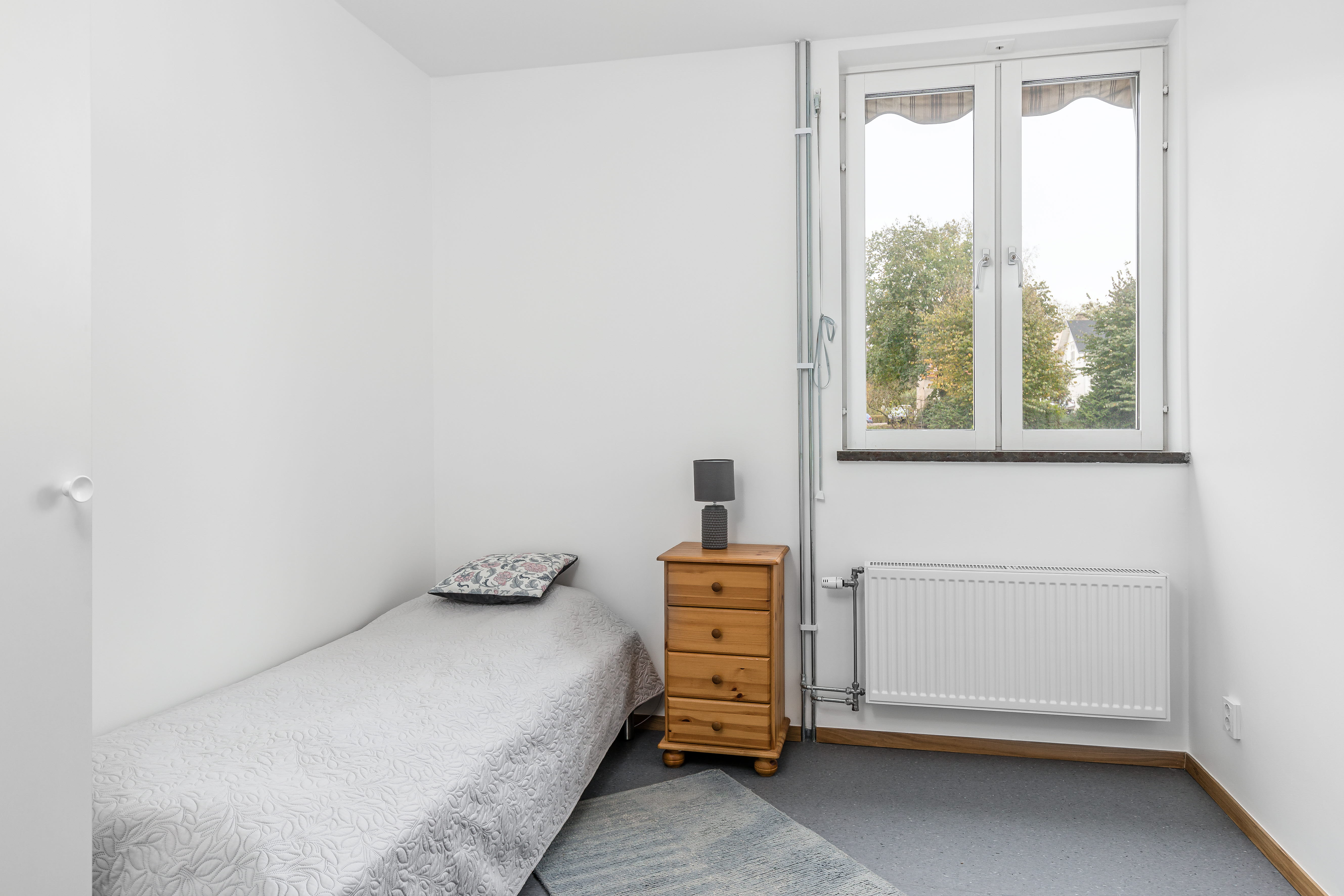 A bedroom with a bed and a window