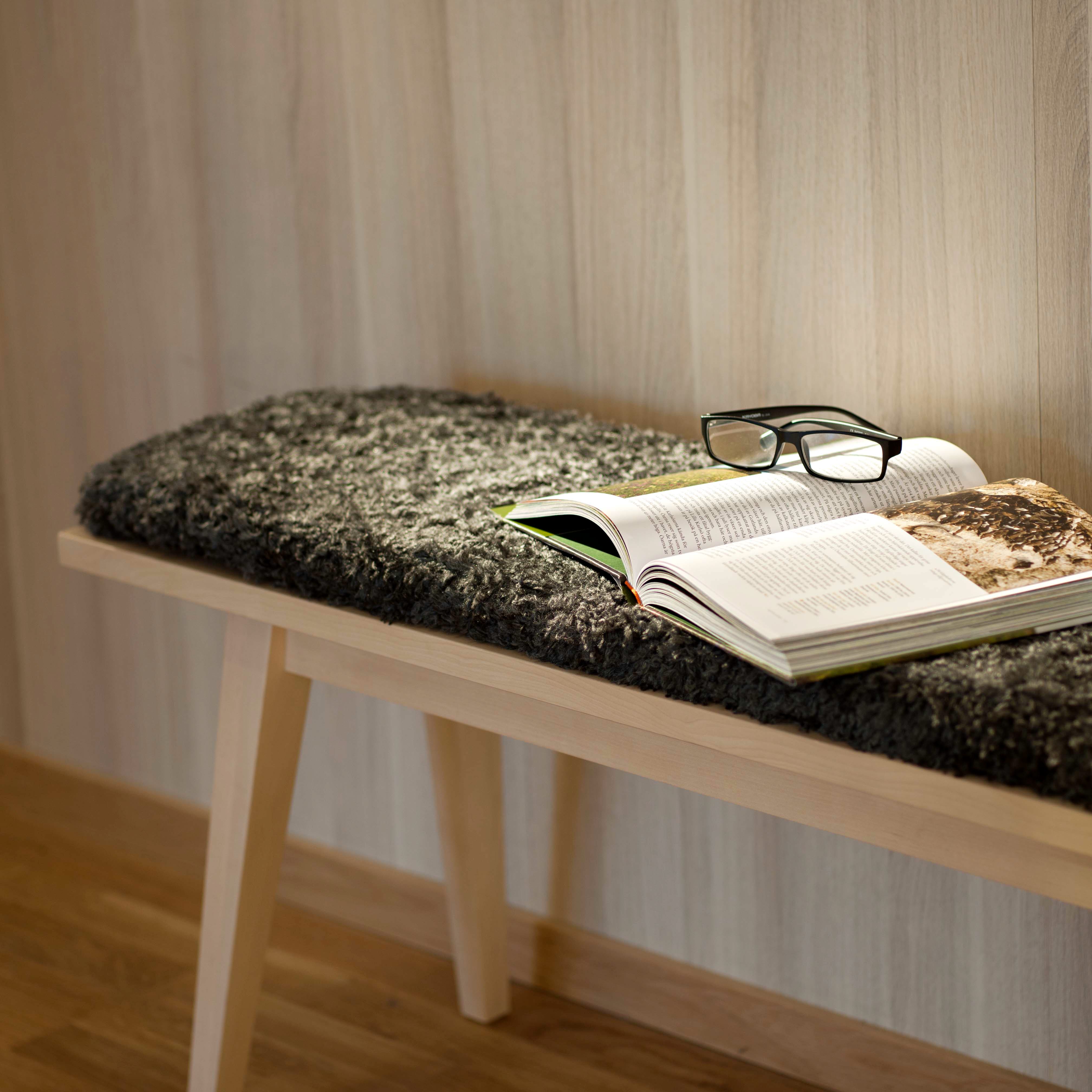 A bench with a book and a pair of reading glasses