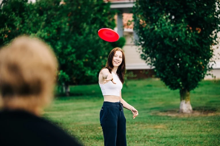 Nuori nainen heittää frisbeetä.
