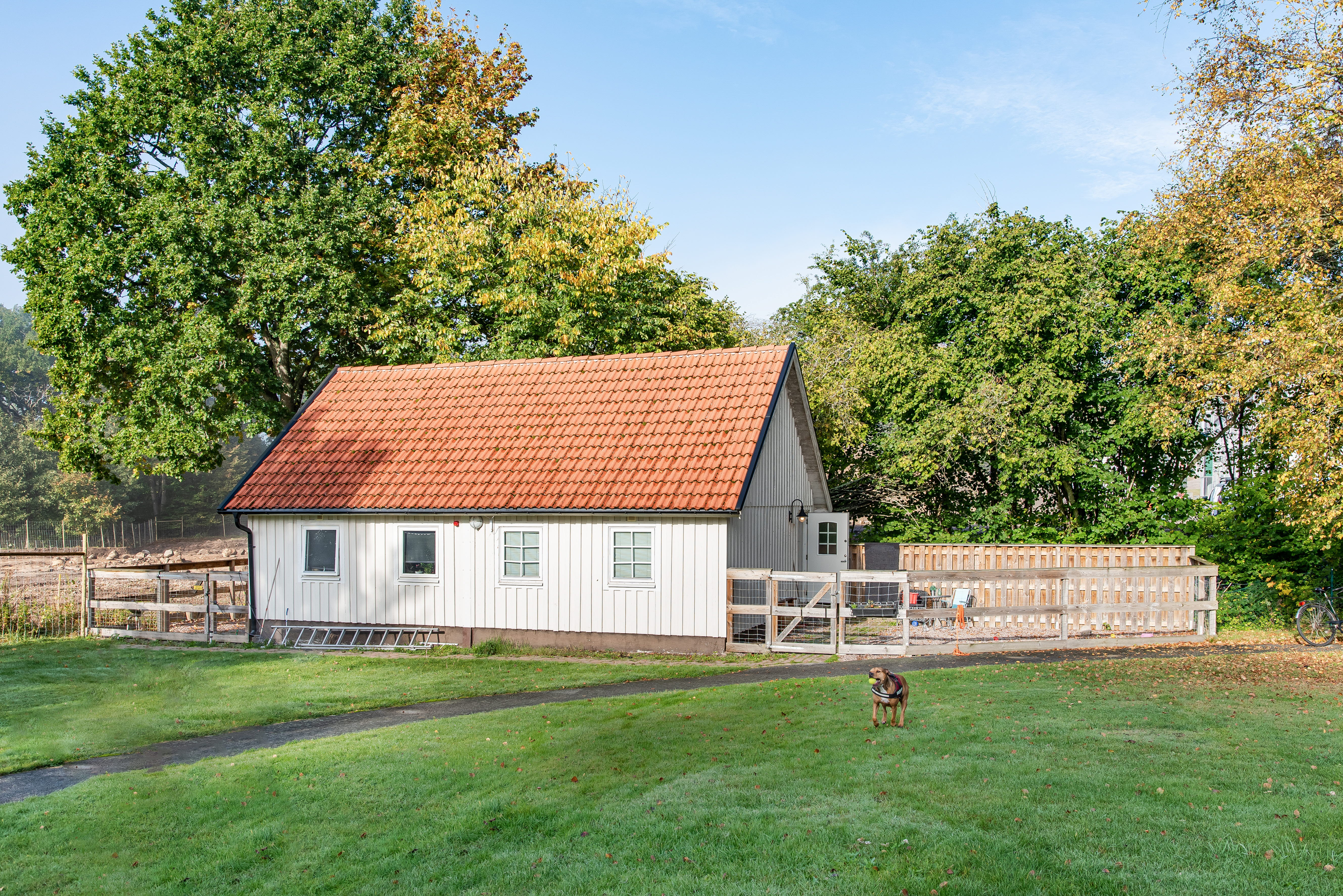 A large green field in front of a house
