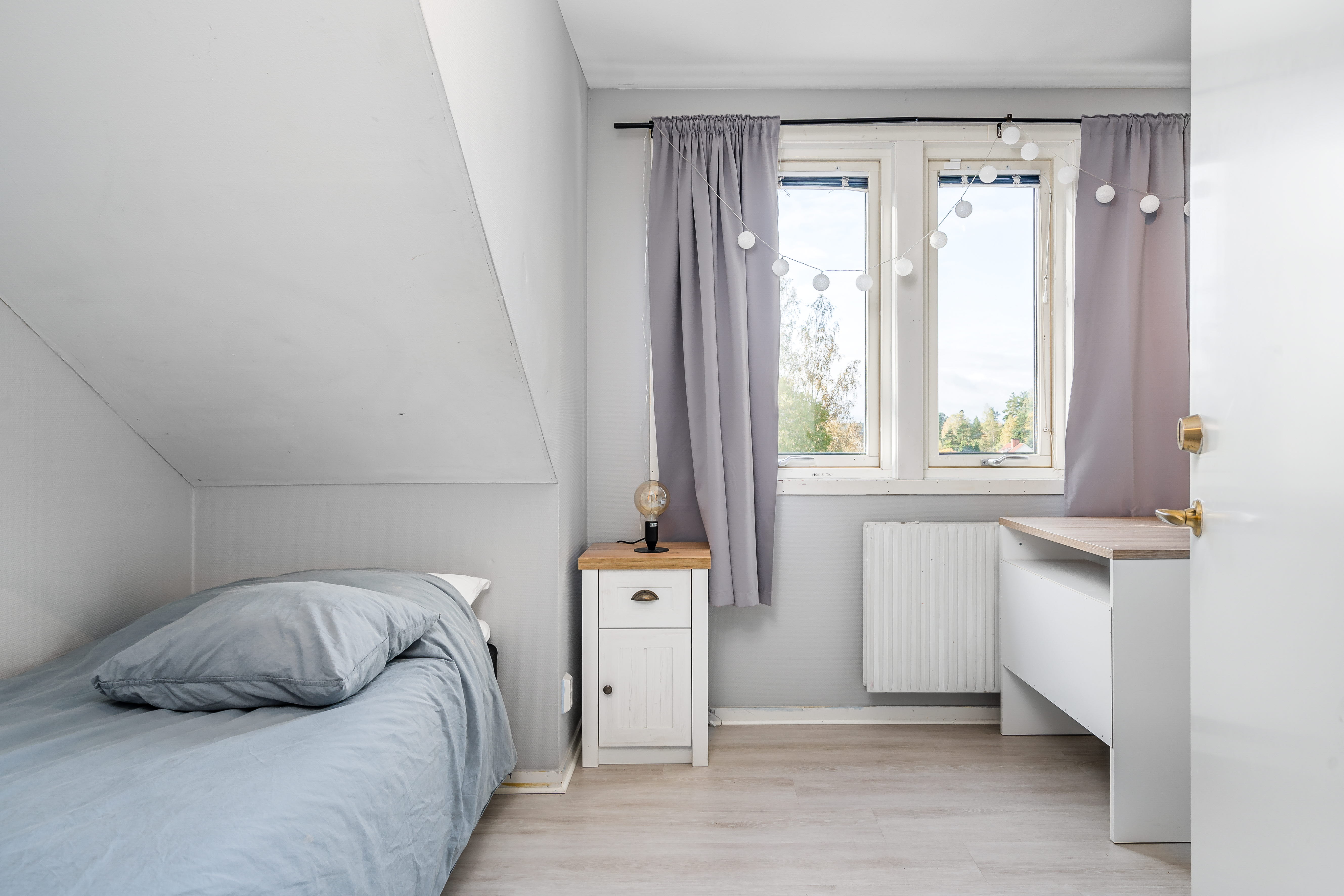 A bedroom with a bed and a window