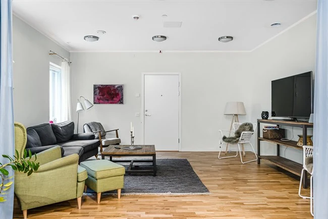 A living room filled with furniture on top of a hard wood floor