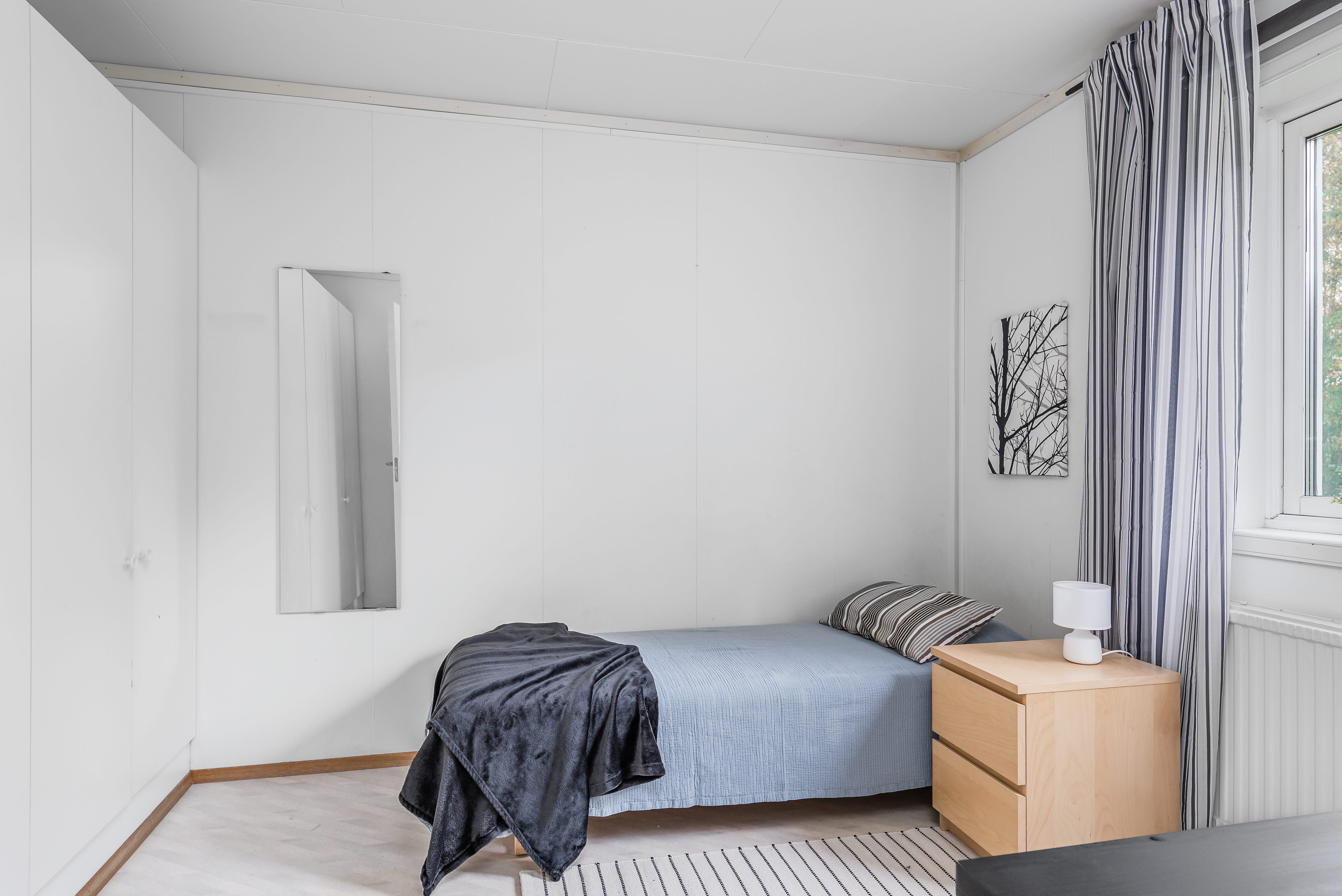 A bedroom with a bed and desk in a room