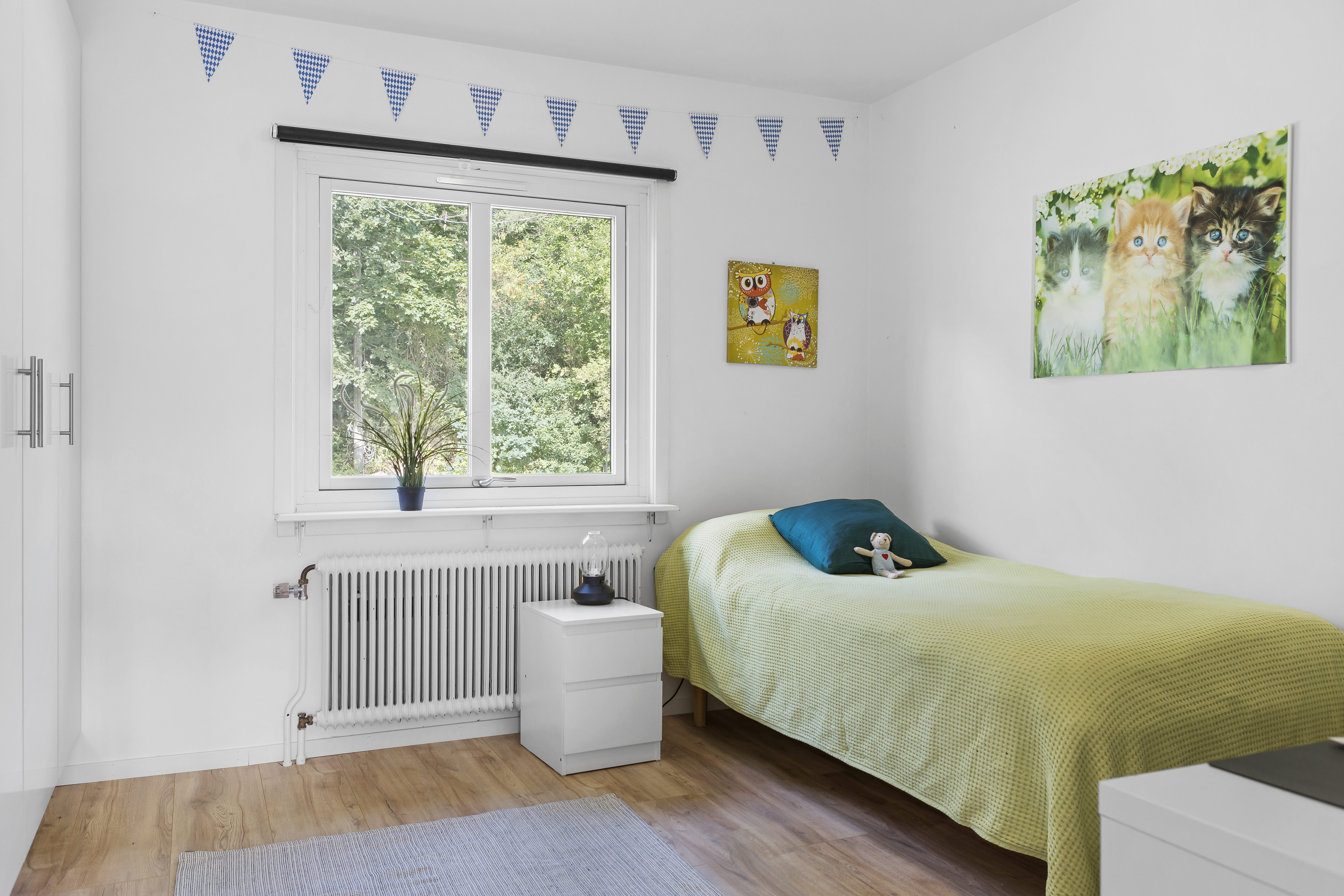 A bedroom with a bed and desk in a room