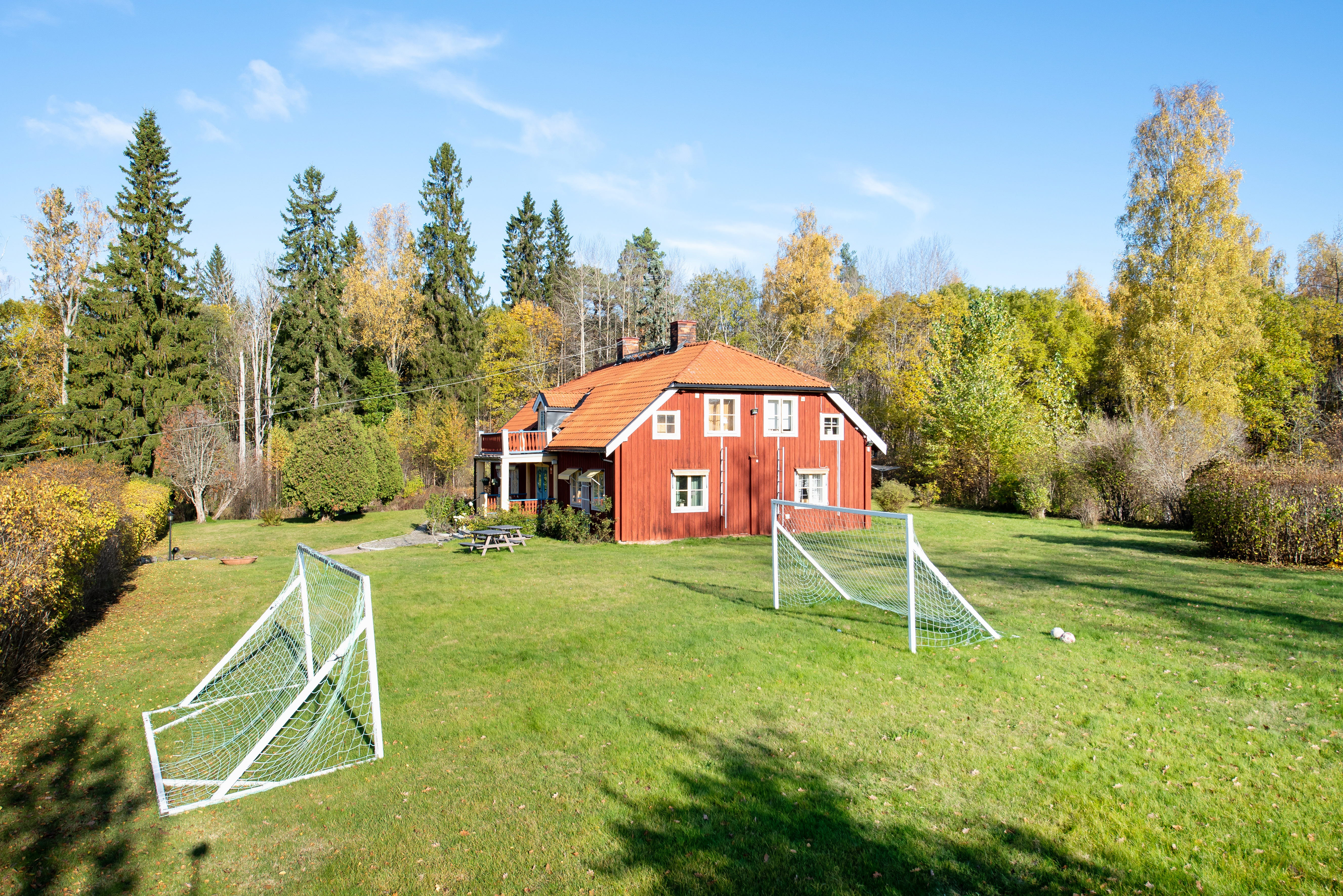 A small house in the middle of a lush green field