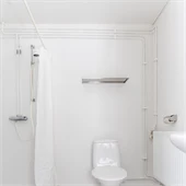 Badrum med grått golv och vita väggar 