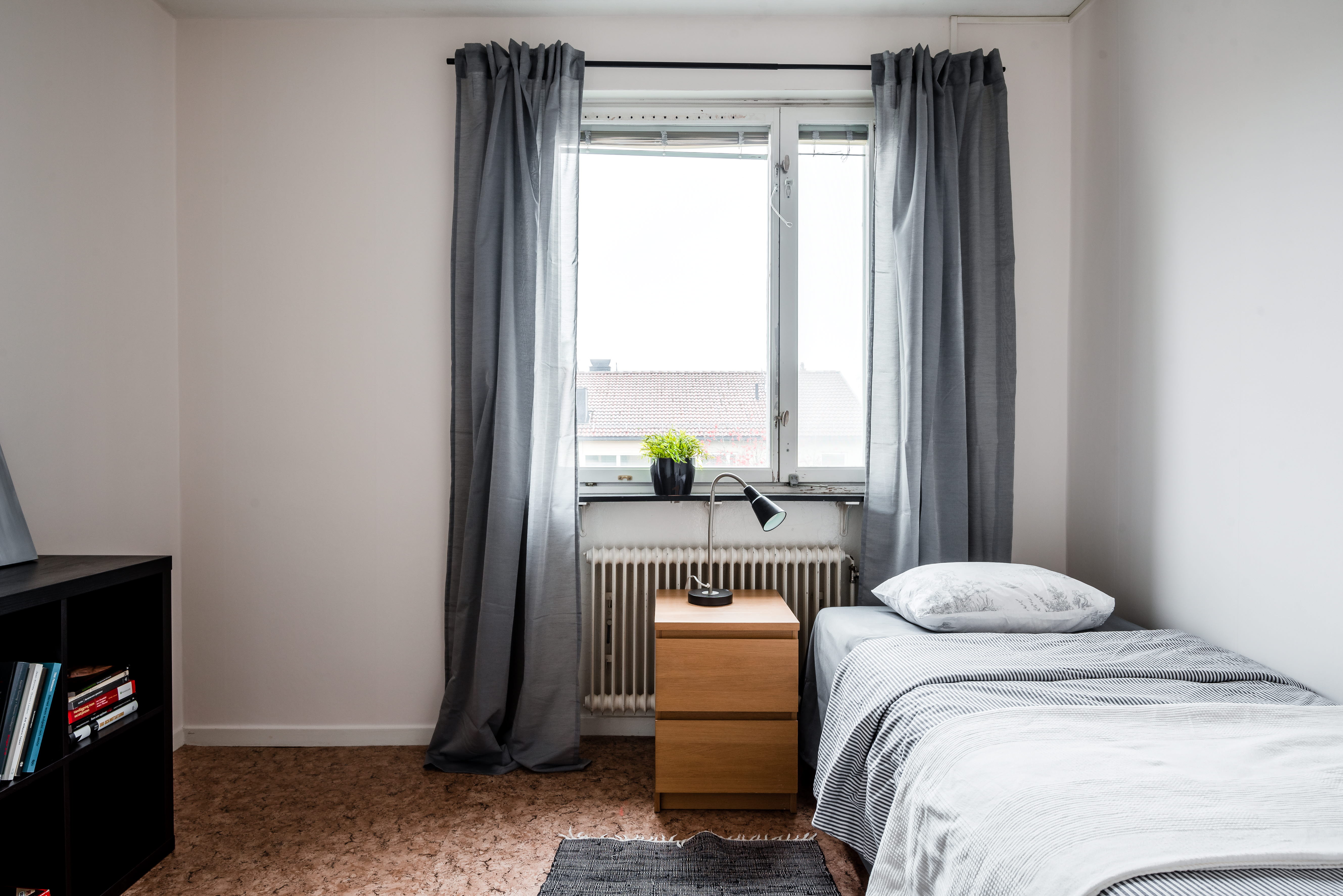 A bedroom with a bed and window in a room