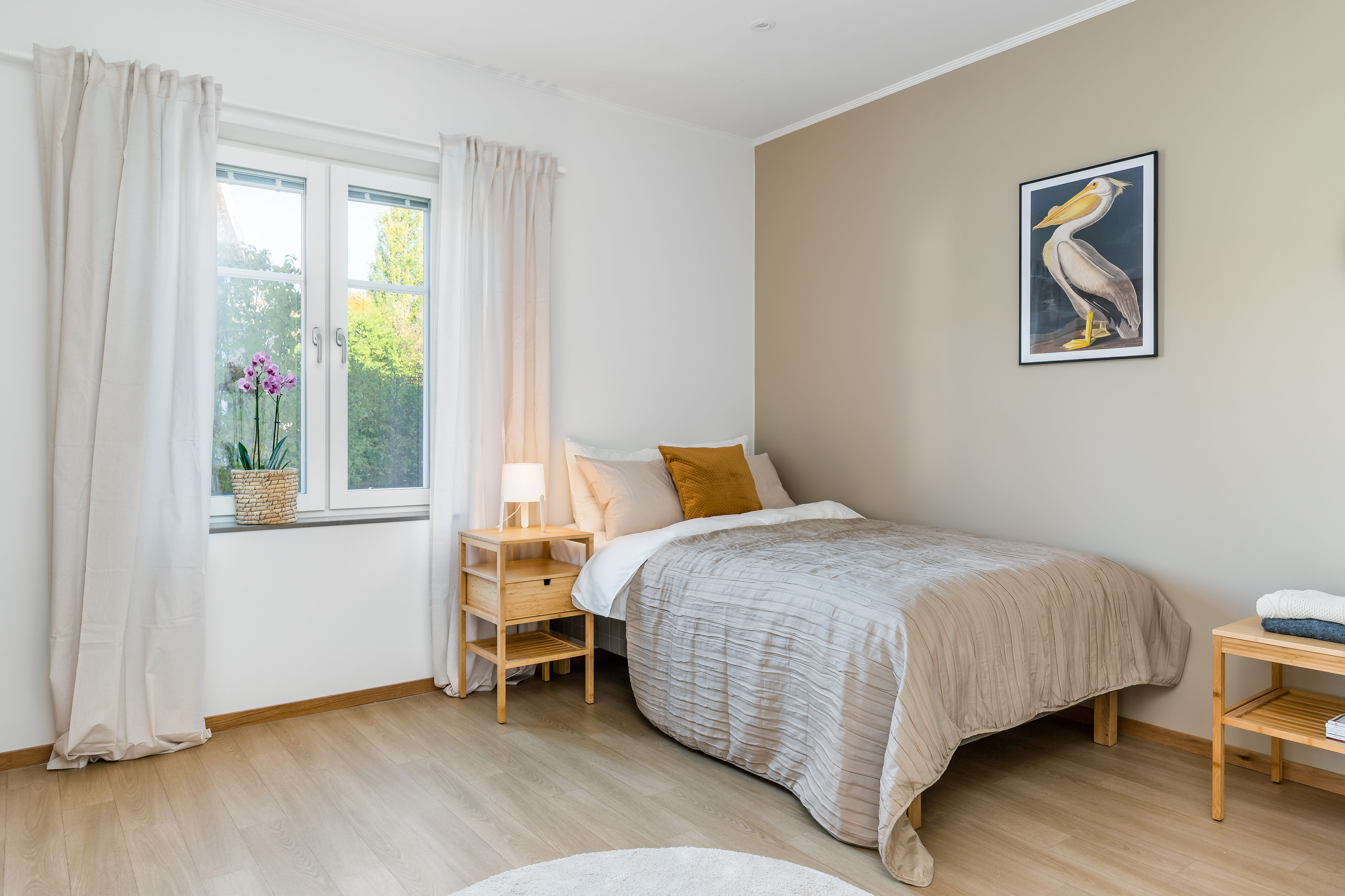 A bedroom with a bed and desk in a room