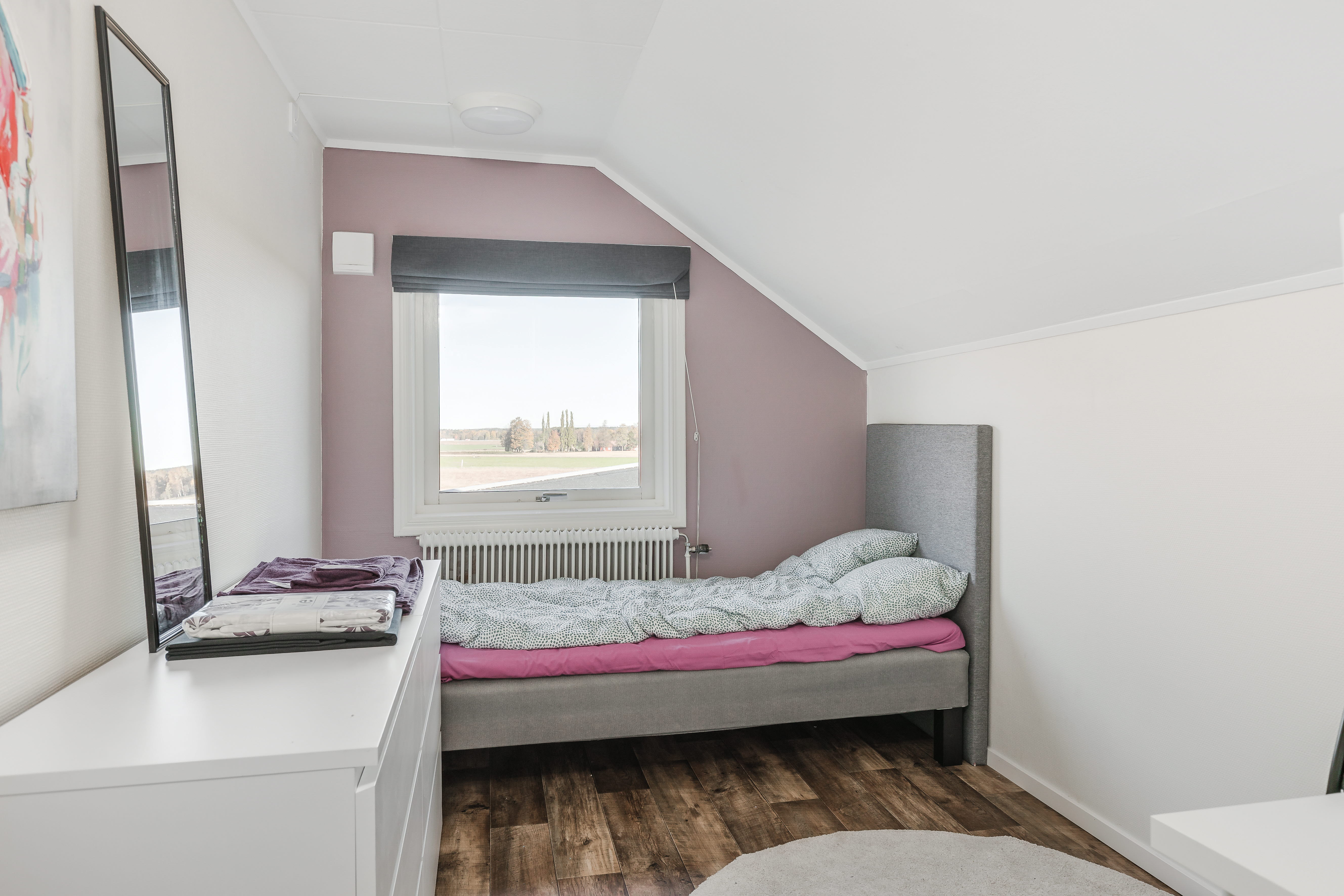A bedroom with a bed and a mirror