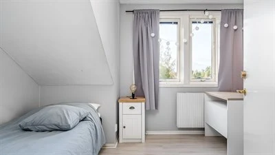 A bedroom with a bed and a window