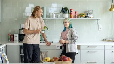 A man and woman standing in a kitchen