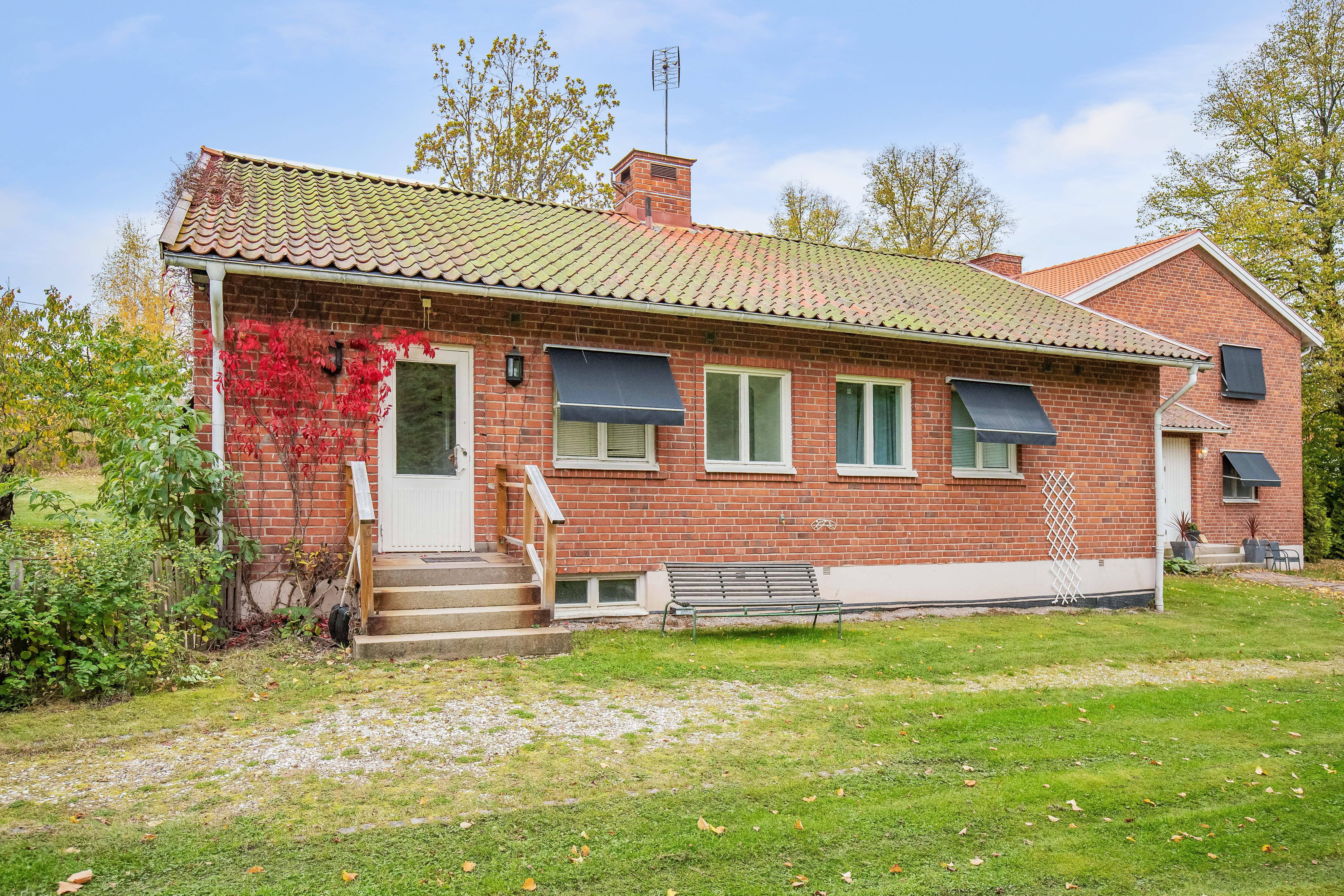 A large brick building with grass in front of a house
