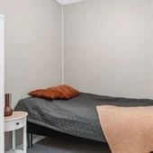 A bedroom with a bed and desk in a room