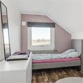 A bedroom with a bed and a mirror