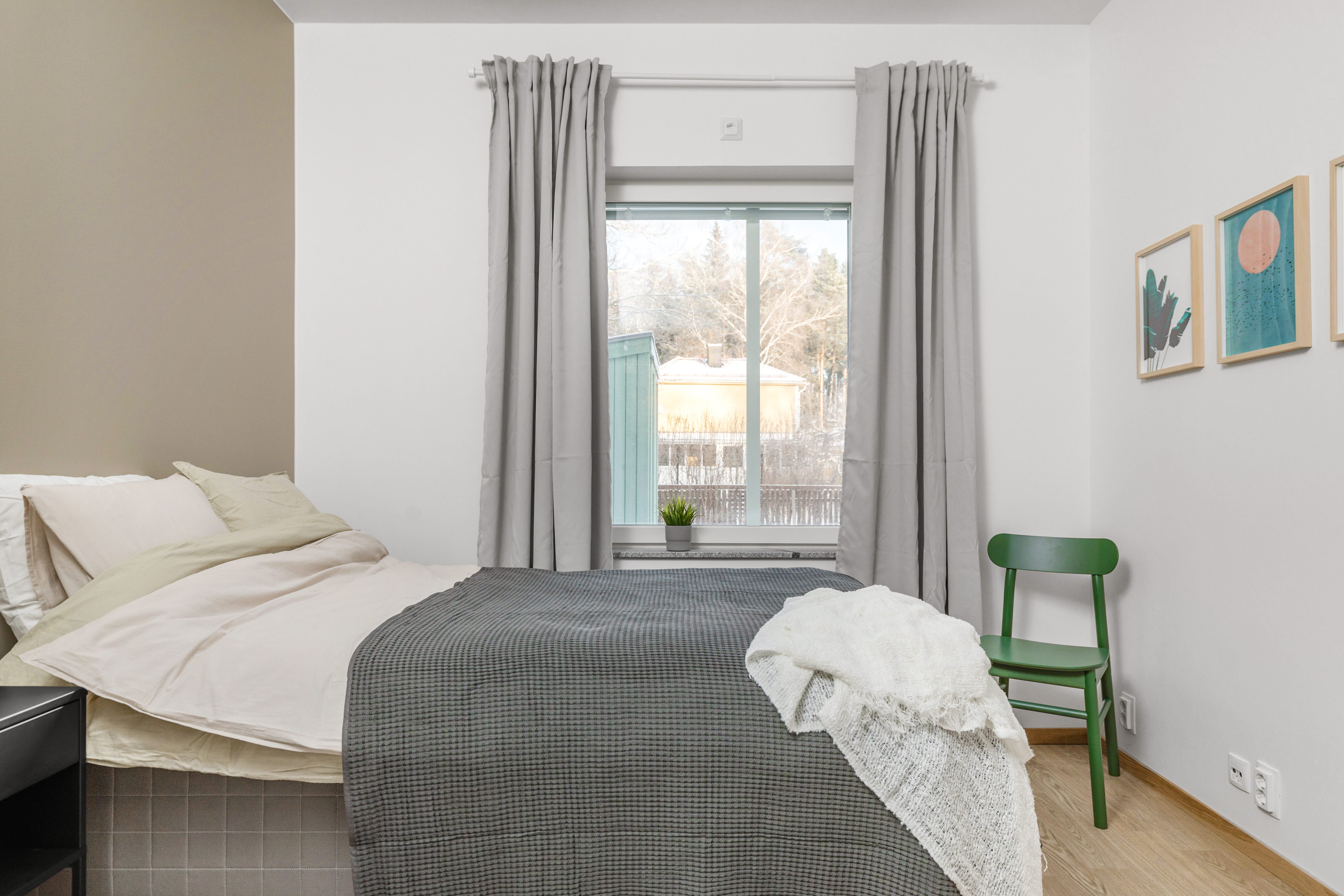 A bedroom with a bed and desk in a room